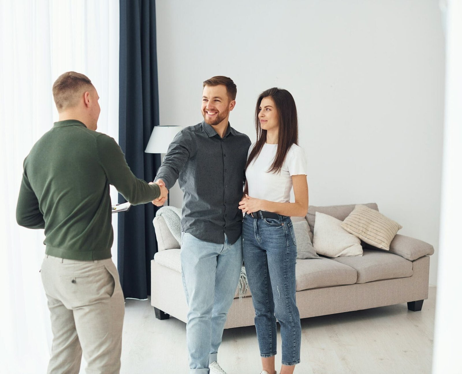 Salesman helps young couple in choosing an apartment. Conception of business and rent